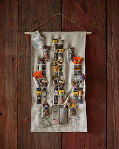 a tea towel hanging on a wooden wall with pictures and magnets attached to it