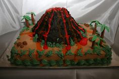 a cake that is shaped like a volcano with trees and rocks on the side,