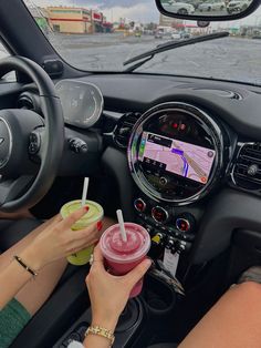 a woman driving a car with a drink in her hand