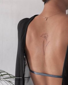 the back of a woman's body with a flower tattoo on her left side