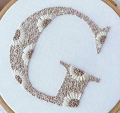 an embroidered letter q with flowers on it