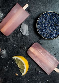 two popsicles with lemon slices and lavender sprinkles next to ice cream