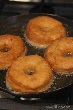 four donuts frying in a pan on the stove