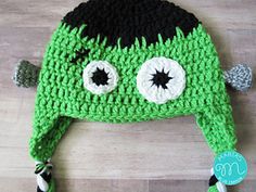 a crocheted green hat with eyes and ears