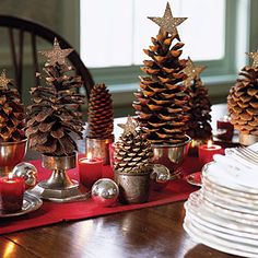 pine cones and silver cups are sitting on a red place mat, along with other christmas decorations