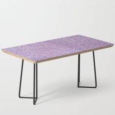 a pink table with black metal legs on a white background, it looks like an abstract piece of art