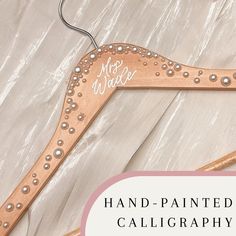 a wooden hanger with the words hand painted calligraphy on it