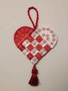 an ornament shaped like a heart hanging from a string