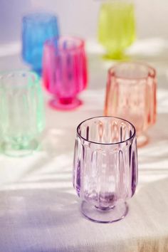 several different colored glasses sitting on top of a table