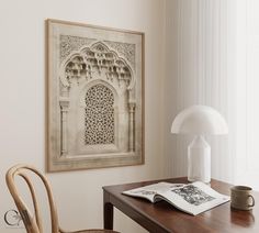 a wooden table topped with a white lamp next to a painting on the wall above it