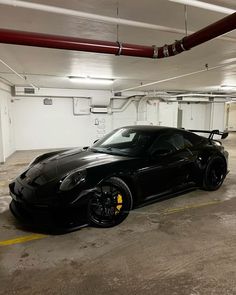 a black sports car parked in a parking garage