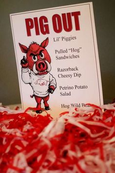 a pig out sign sitting on top of red shredded paper