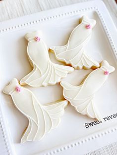 three decorated cookies sitting on top of a white plate