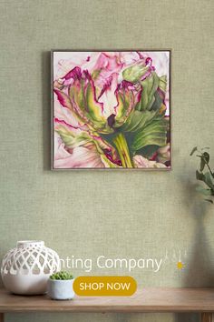 a painting hanging on the wall next to a vase with flowers and plants in it