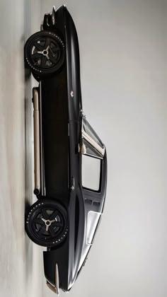 a car shaped clock mounted to the side of a wall next to a white wall