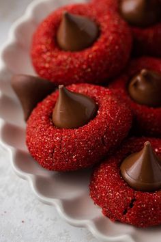 chocolate covered cookies on a plate with red sprinkles