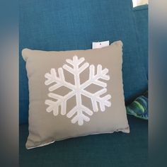 a white snowflake pillow on a blue couch