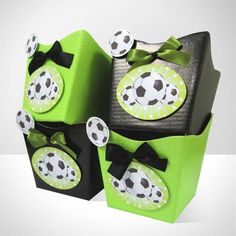 three green boxes with soccer themed designs on the top and bottom, one has a black bow