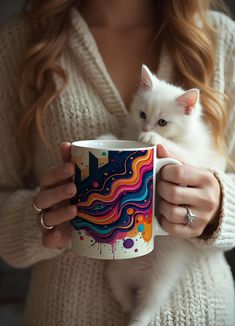 a woman holding a coffee mug with a white cat on her arm and colorful swirls