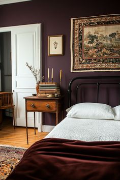 a bed sitting in a bedroom next to a wooden dresser and table with a rug on top of it