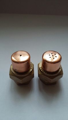 two brass knobs with holes in the middle