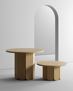 two round tables sitting next to each other in front of a white wall and mirror