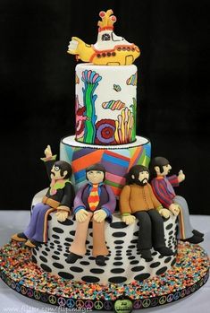 a multi - tiered cake with people sitting on it