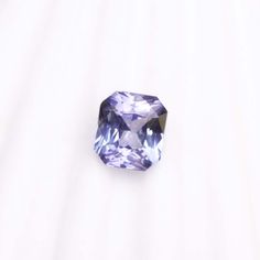 a tan and purple diamond sitting on top of a white surface