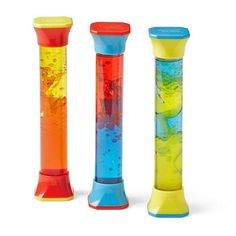 three different colored plastic objects on a white background