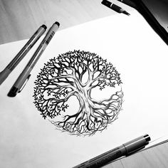 a drawing of a tree with leaves and branches on paper next to markers, pens and pencils