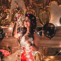 a woman in a wedding dress is surrounded by balloons and confetti as she smiles