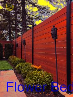 the side of a wooden fence with flowers in it