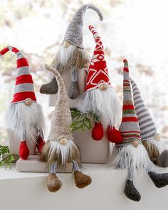 a group of gnome figurines sitting on top of a white shelf next to a window