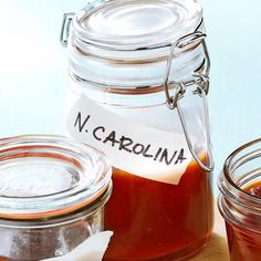 three jars filled with sauce sitting on top of a table