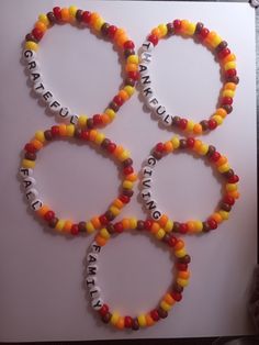 four bracelets made out of candy beads with words on them