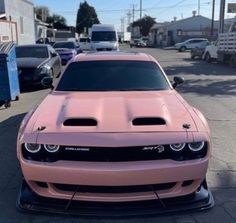 the front end of a pink car parked in a parking lot