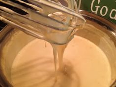 a whisk is being poured into a bowl filled with batter for cake mix