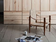 a wooden chair sitting on top of a hard wood floor next to a cup of coffee