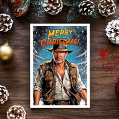 a christmas card with the image of indiana jones on it, surrounded by pine cones