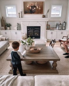 a little boy standing in front of a coffee table