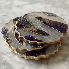 three pieces of glass sitting on top of a white tablecloth covered surface with gold trimmings