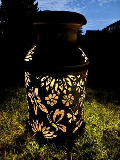 a lit up vase sitting in the grass