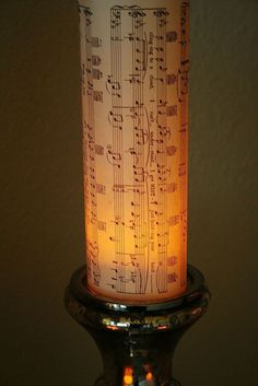 a lit candle with musical notes on it