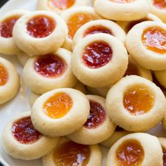 small pastries with jam on them sitting on a plate