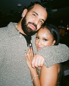 a man and woman hugging each other in front of a bar with the lights on