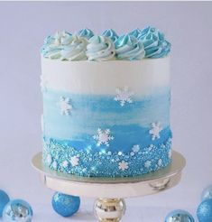 a blue and white frosted cake sitting on top of a table