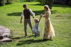 a man and woman are holding hands as a child holds the hand of an adult