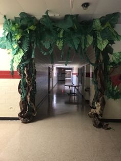 a hallway decorated with paper mache leaves and vines for the entrance to an office building