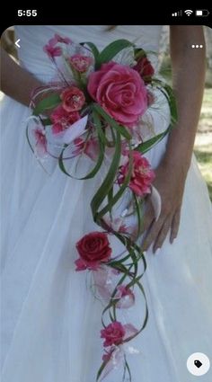 a bride holding a bouquet of pink flowers