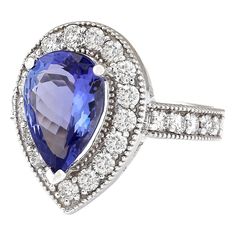 Stamped: 14K White Gold Total Ring Weight: 7.1 Grams Ring Length: N/ARing Width: N/A Gemstone Weight: Total Natural Tanzanite Weight is 3.02 Carat (Measures: 13.20x8.70 mm) Color: Blue Diamond Weight: Total Natural Diamond Weight is 1.10 Carat Quantity: 27 Color: F-G, Clarity: VS2-SI1 Face Measures: 19.25x14.30 mm Sku: [703852W] White Gold Gemstones With Halo Setting For Formal Events, Formal White Gold Gemstones With Halo Setting, Formal Tanzanite Round Cut Diamond Ring, Formal Tanzanite Diamond Ring With Round Cut, Classic Tanzanite Ring For Formal Occasions, Formal Tanzanite Fine Jewelry Rings, Formal Pear-shaped Sapphire Ring With Brilliant Cut, Tanzanite Brilliant Cut Formal Rings, Classic Tanzanite Diamond Ring In White Gold